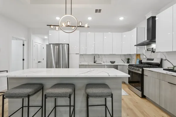 a kitchen with stainless steel appliances granite countertop a table chairs sink and cabinets