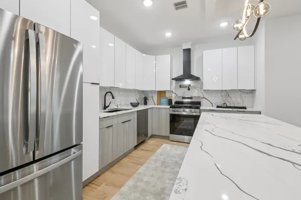 a kitchen with granite countertop a refrigerator stove top oven and sink