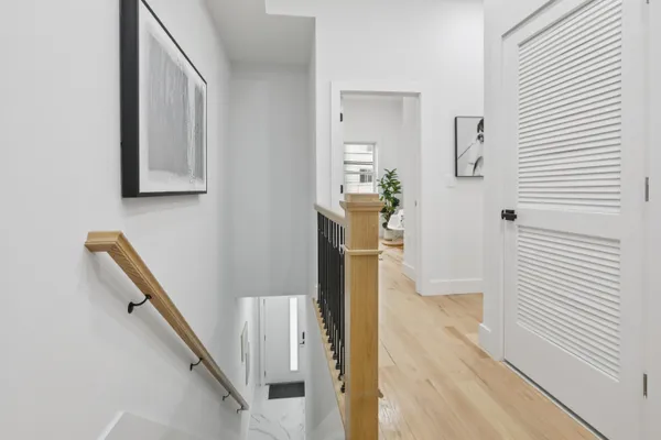 a view of a hallway with wooden floor and staircase