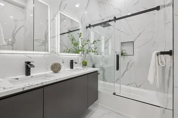 a bathroom with a granite countertop sink mirror and a shower