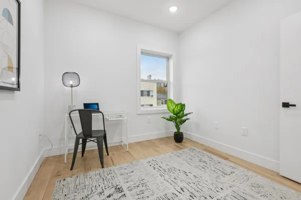 a view of a workspace filled with furniture and wooden floor