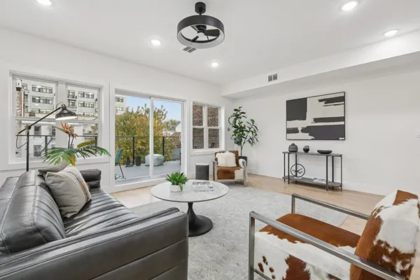 a living room with furniture and a floor to ceiling window