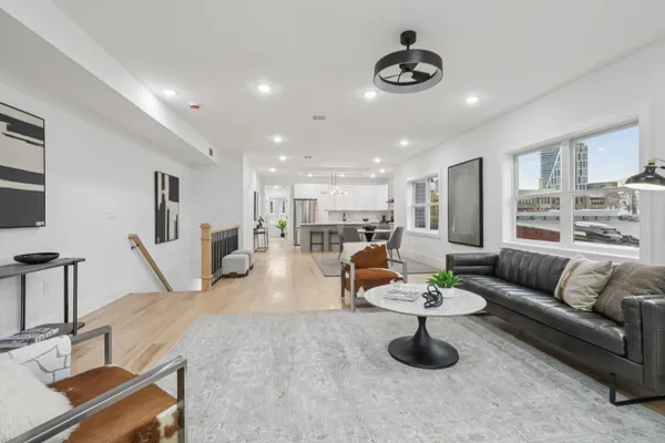 a living room with furniture and a view of kitchen