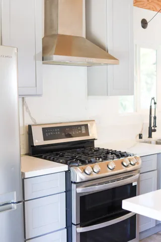 a stove top oven sitting inside of a kitchen