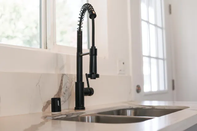 a view of a faucet a sink and a window