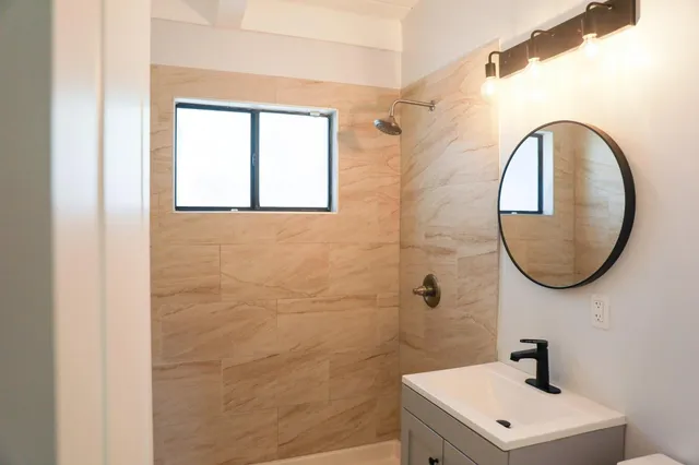 a bathroom with a sink a mirror and a shower