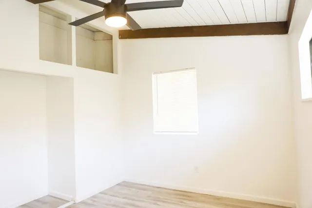 a view of a small space with wooden floor and a ceiling fan