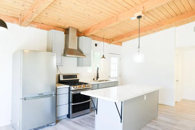 a kitchen with stainless steel appliances a stove a refrigerator and a cabinets