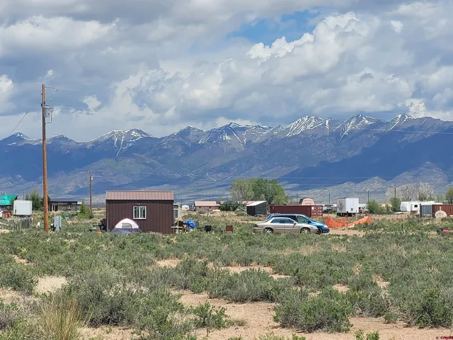a view of a house with a yard and a car park side of it