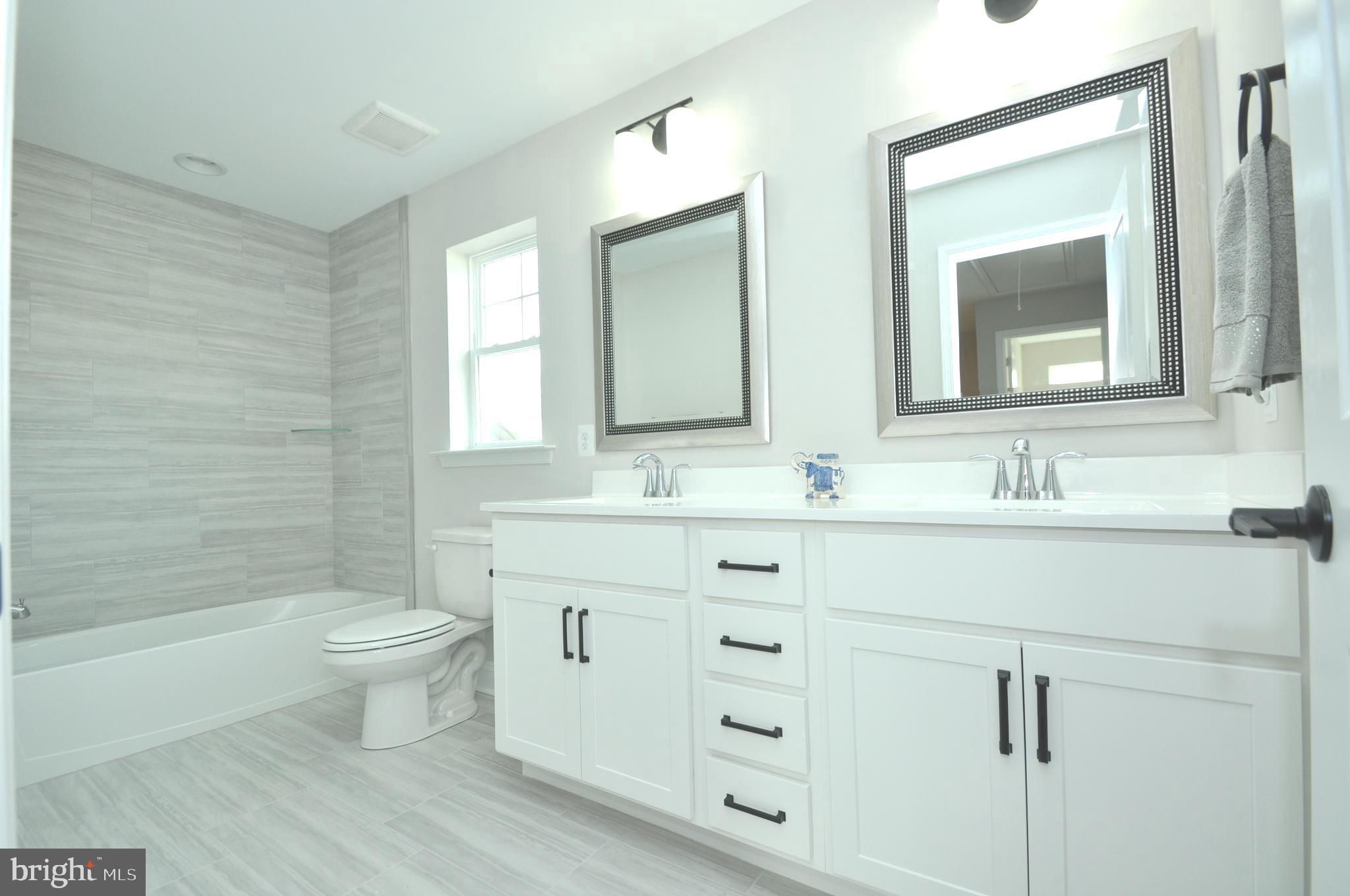 9138 Eton Road Silver Spring, MD 20901 - Photo 12 of 24 a bathroom with a double vanity sink mirror and toilet