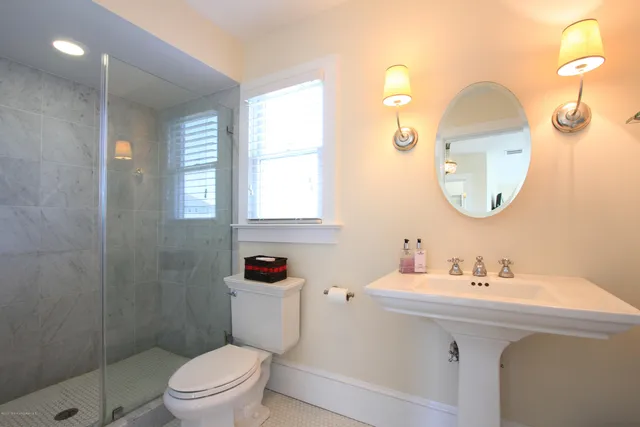 a bathroom with a toilet sink and mirror