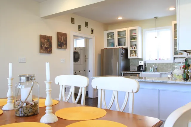 a kitchen with stainless steel appliances a dining table chairs and chandelier