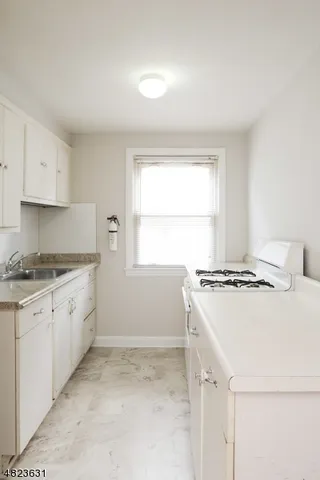 a kitchen with a stove cabinets and a window