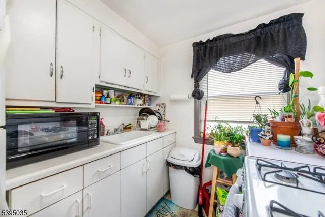 a kitchen with a sink a stove and cabinets