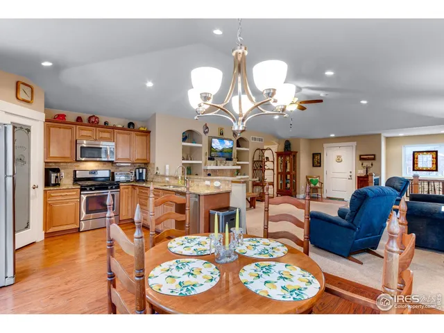 a living room with lots of furniture kitchen view and a chandelier