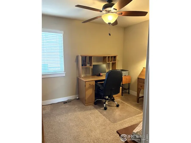 a view of a workspace with furniture and a window