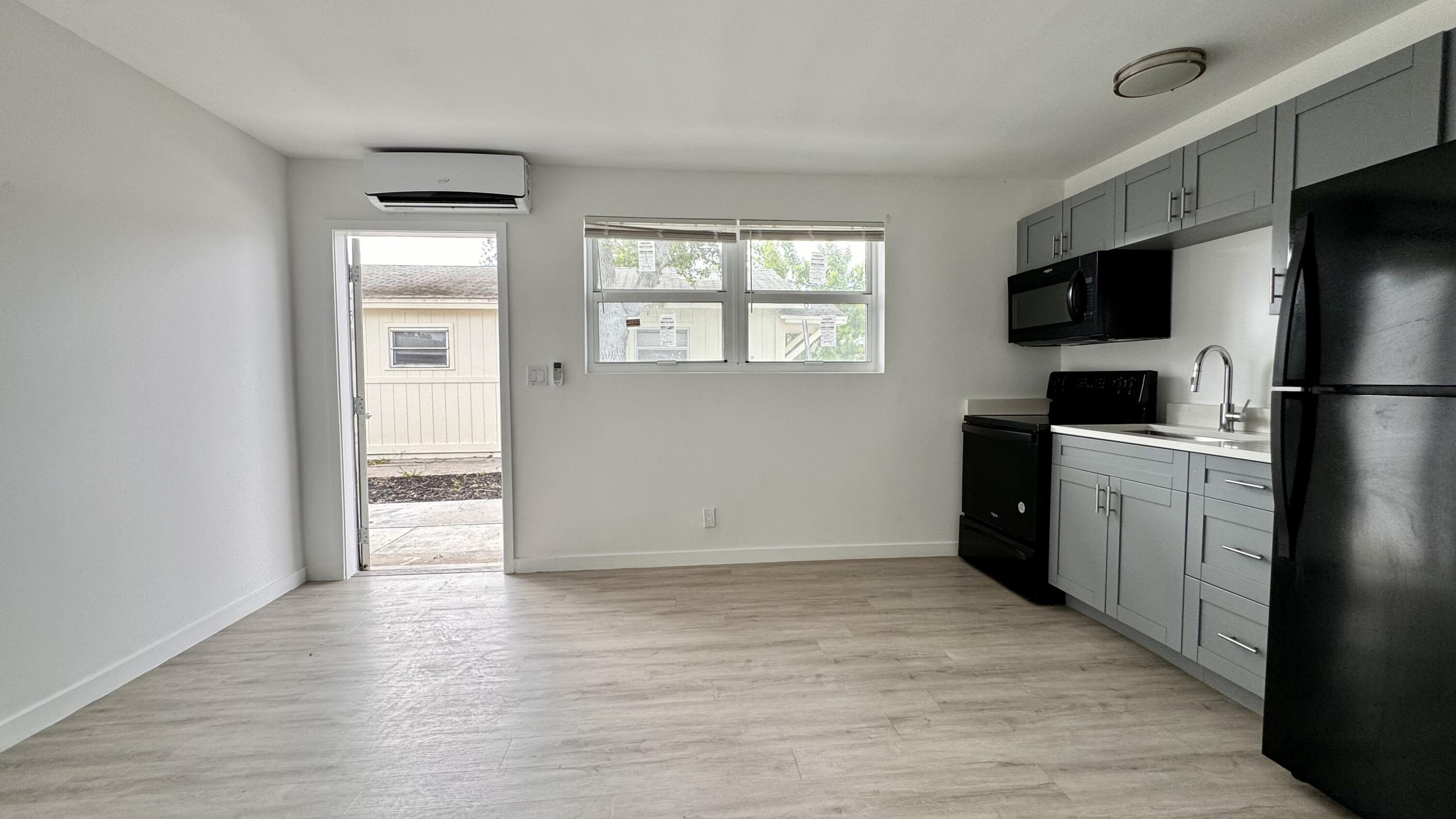 225 South F Street, Unit 6 Lake Worth Beach, FL 33460 - Photo 5 of 11 a view of a kitchen with a sink refrigerator and wooden floor