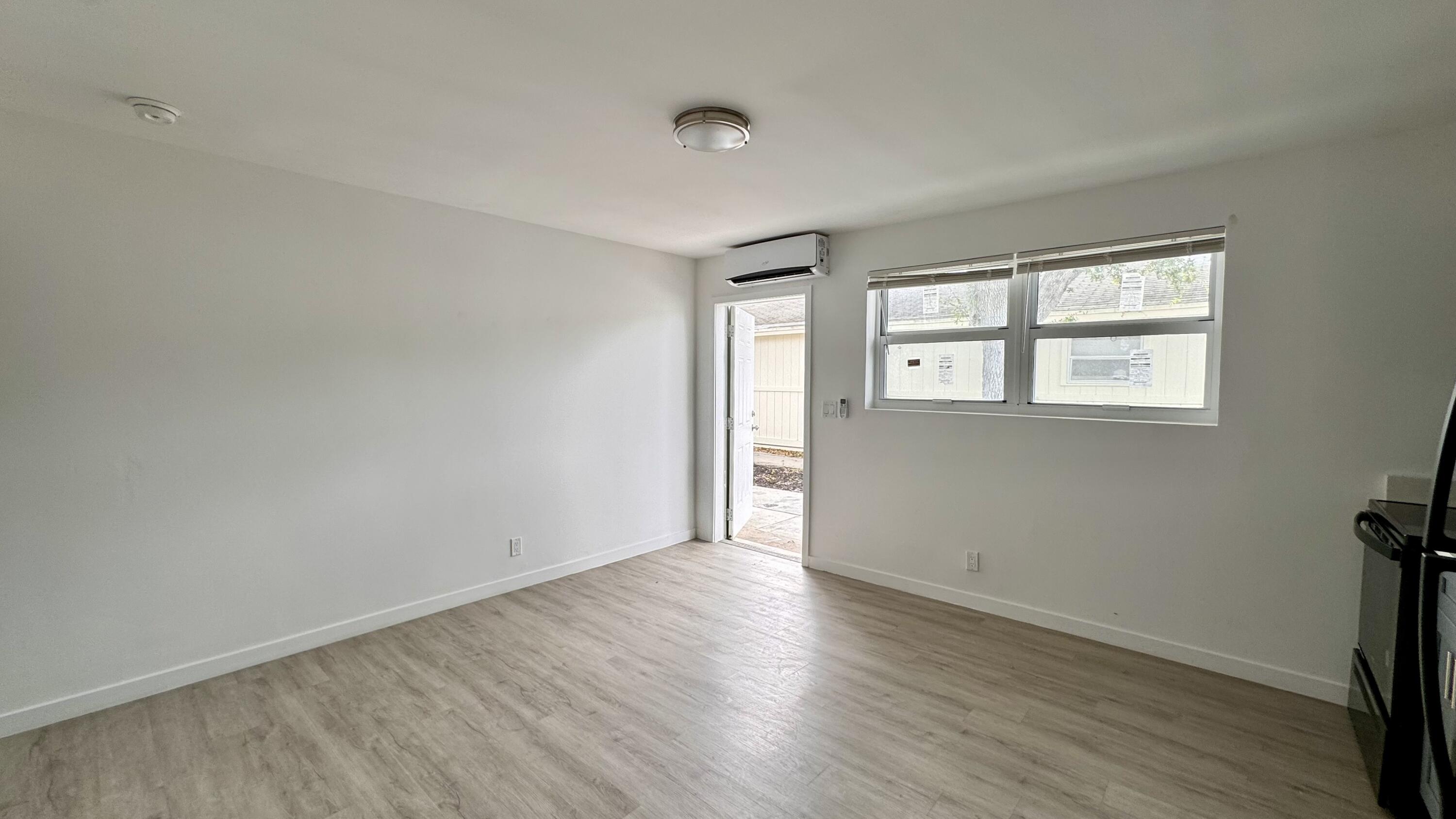 225 South F Street, Unit 6 Lake Worth Beach, FL 33460 - Photo 7 of 11 an empty room with wooden floor and windows