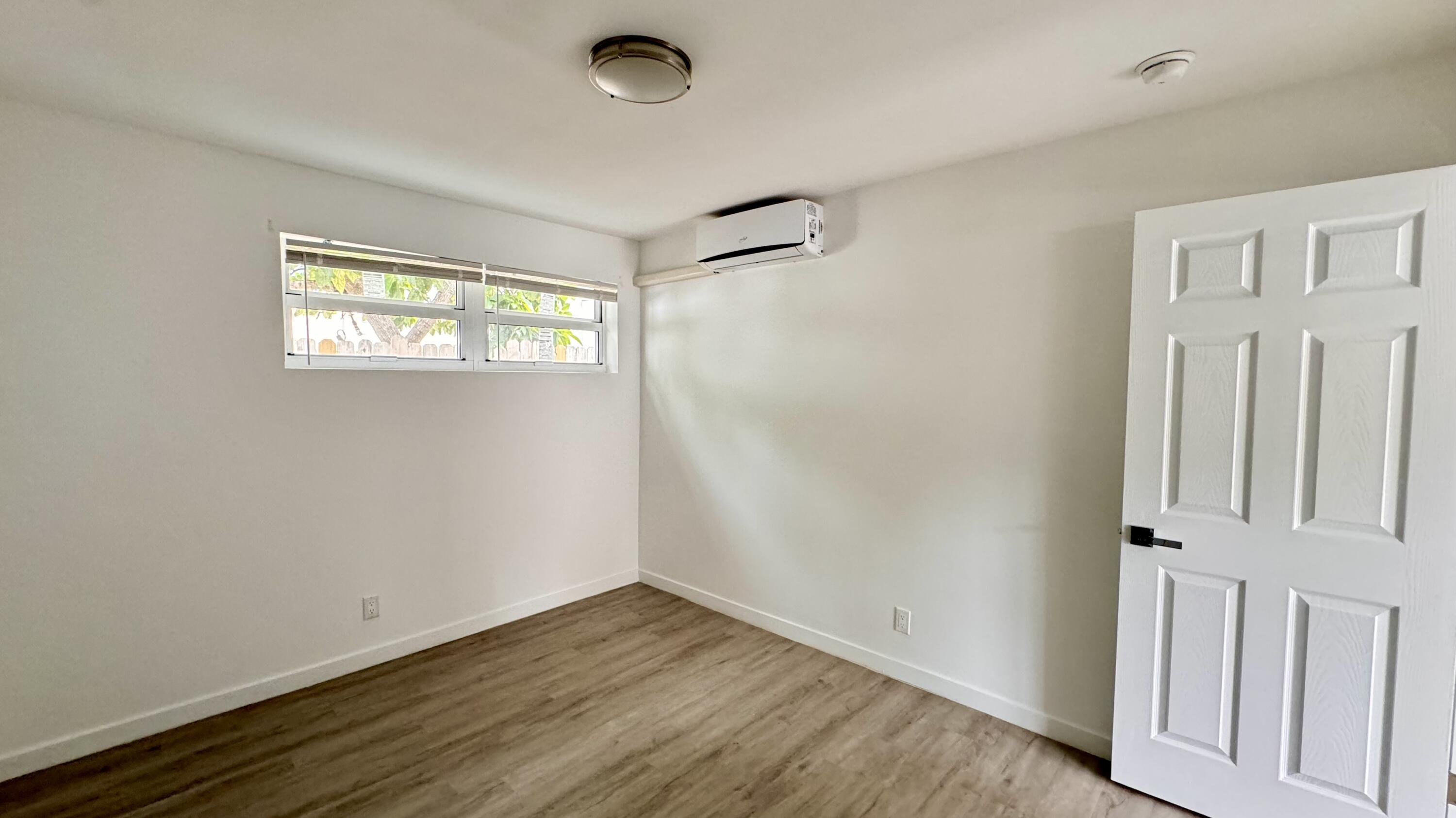 225 South F Street, Unit 6 Lake Worth Beach, FL 33460 - Photo 10 of 11 an empty room with wooden floor and windows