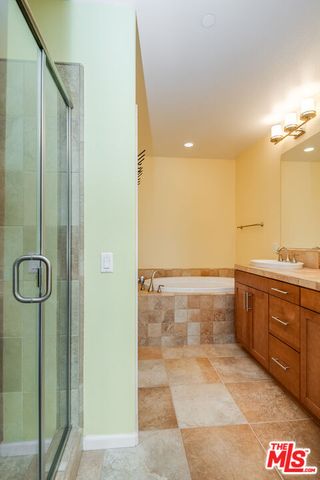 a bathroom with a granite countertop sink a mirror and shower