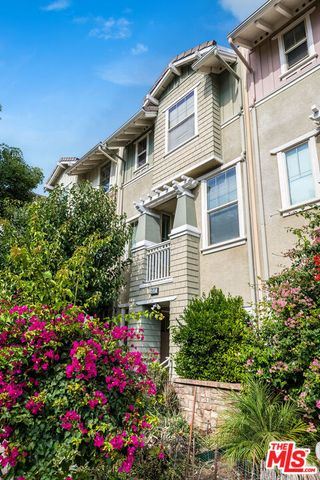 a view of a house with a yard and potted plants