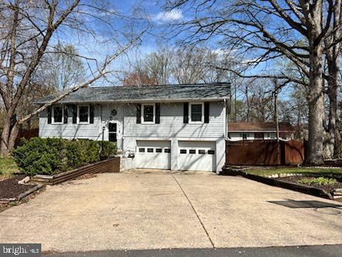 a view of a white house with large windows and a table and chairs under an umbrella