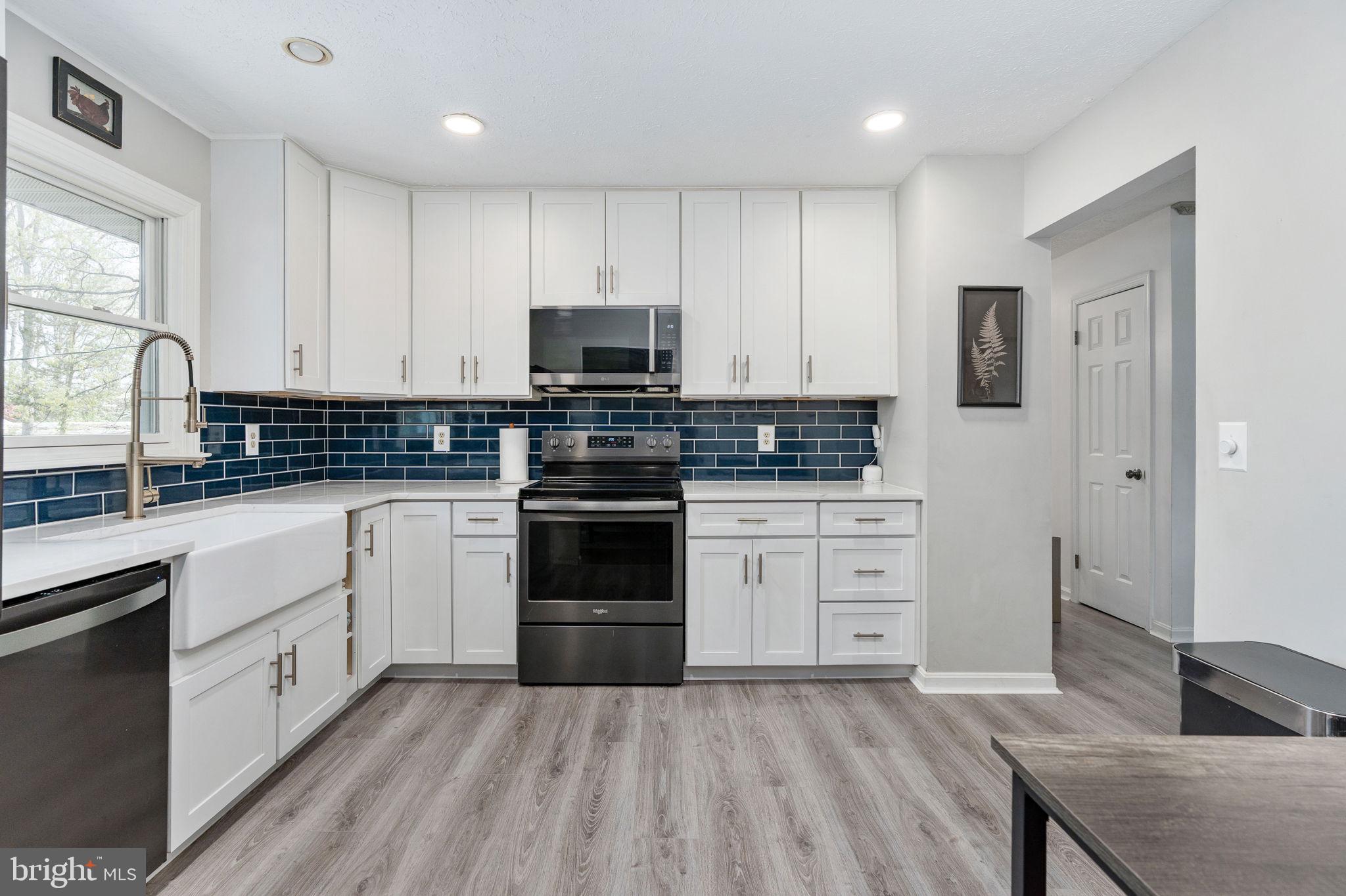 15195 Dyers Road Woodbridge, VA 22193 - Photo 15 of 53 a kitchen with granite countertop white cabinets and stainless steel appliances