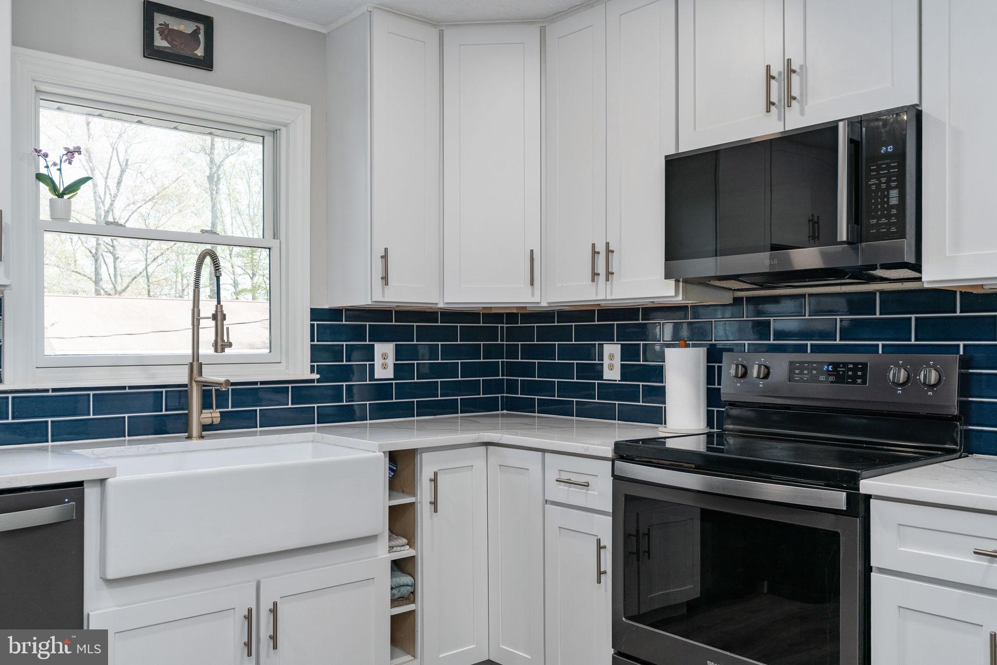 15195 Dyers Road Woodbridge, VA 22193 - Photo 16 of 53 a kitchen with stainless steel appliances a stove microwave and sink