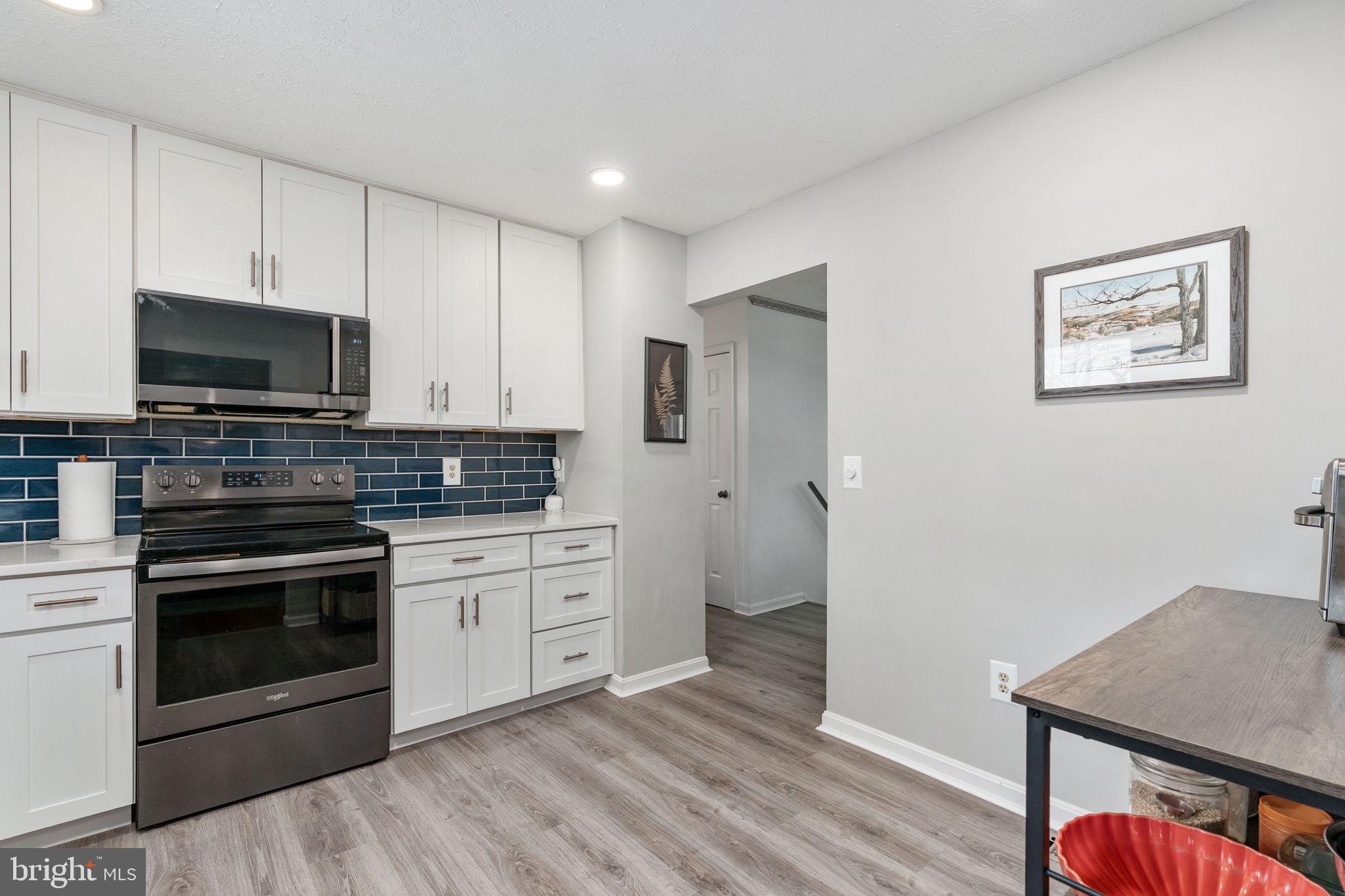 15195 Dyers Road Woodbridge, VA 22193 - Photo 19 of 53 a kitchen with stainless steel appliances a stove microwave and sink