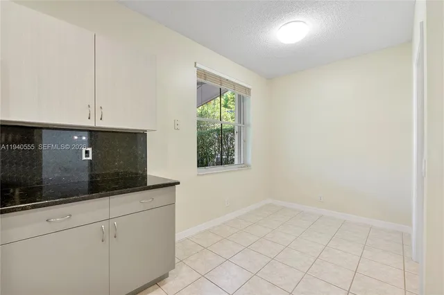 a kitchen with granite countertop white cabinets and white appliances
