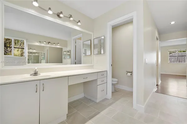a spacious bathroom with a granite countertop sink mirror and toilet