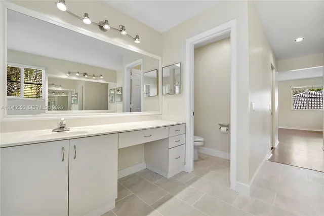 a spacious bathroom with a granite countertop sink mirror and toilet