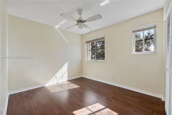 a view of a big room with wooden floor and windows