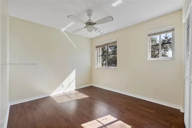 a view of a big room with wooden floor and windows
