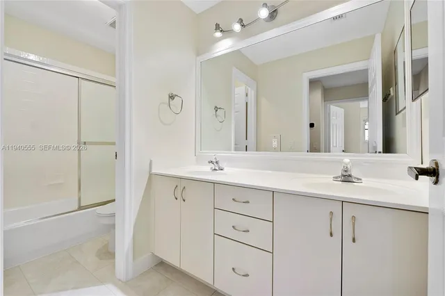 a bathroom with a double vanity sink mirror and next to a window