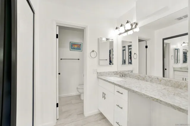 a bathroom with a granite countertop sink and a mirror