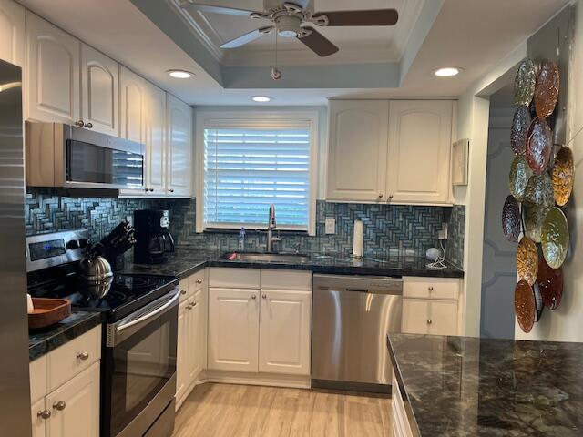 1030 Sugar Sands Boulevard, Unit 171 Singer Island, FL 33404 - Photo 4 of 20 a kitchen with stainless steel appliances granite countertop a stove top oven a sink a microwave and cabinets