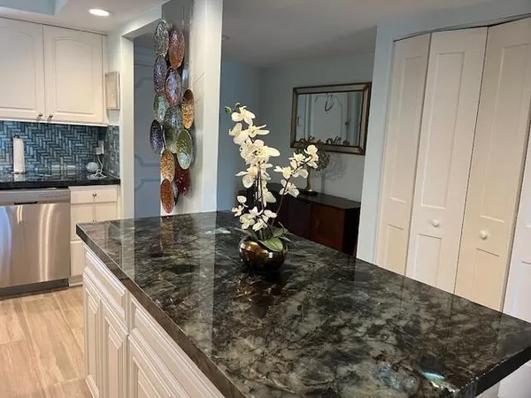 a kitchen with stainless steel appliances granite countertop a sink refrigerator and cabinets