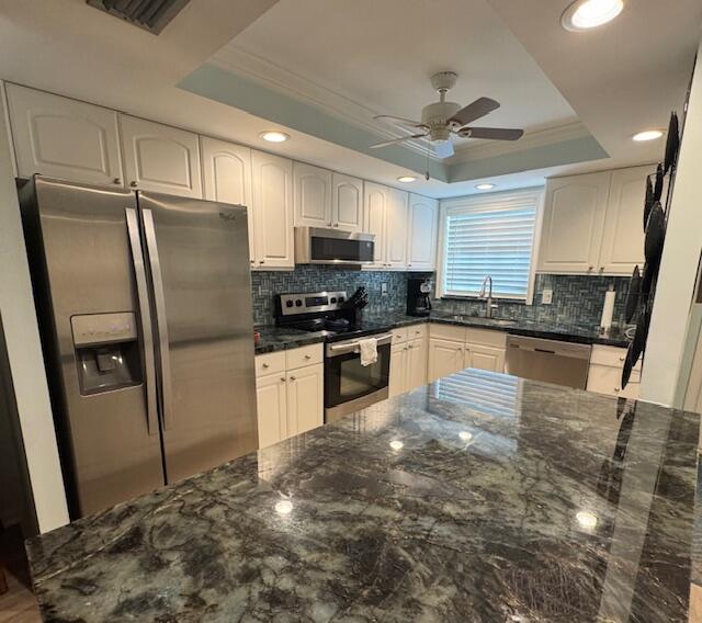 1030 Sugar Sands Boulevard, Unit 171 Singer Island, FL 33404 - Photo 7 of 20 a kitchen with granite countertop a refrigerator a sink a stove a microwave a counter top space and cabinets