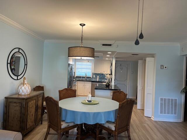 1030 Sugar Sands Boulevard, Unit 171 Singer Island, FL 33404 - Photo 10 of 20 a view of a dining room with furniture a chandelier and wooden floor