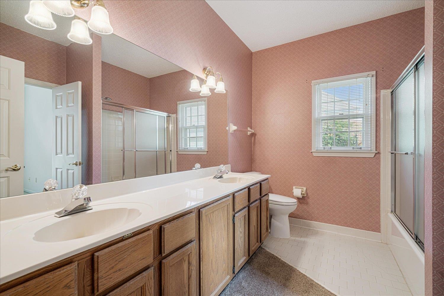 1665 Riverdale Road Germantown, TN 38138 - Photo 29 of 39 a bathroom with a double vanity sink a toilet and a mirror