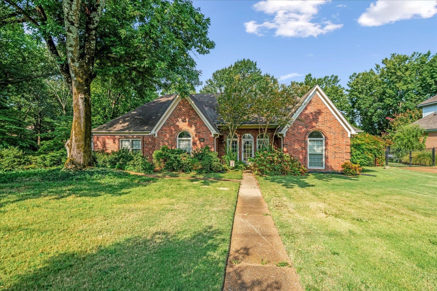 1665 Riverdale Road Germantown, TN 38138 - Photo 4 of 39 a front view of a house with a yard and trees