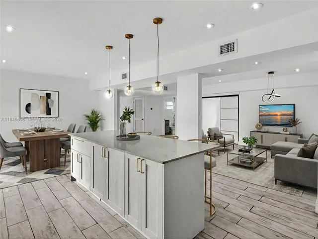 a large kitchen with kitchen island a large counter space a sink stainless steel appliances and cabinets