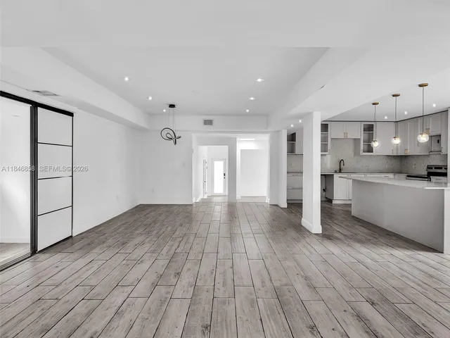 a view of a kitchen with wooden floor and a window