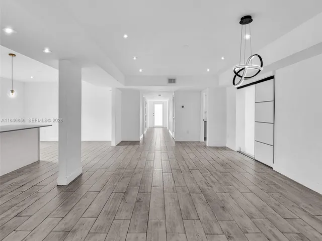 a view of empty room with wooden floor and windows