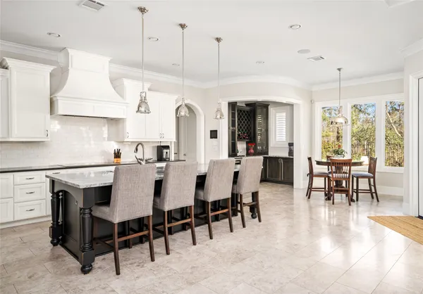 a view of dining table chairs kitchen island and stainless steel appliances