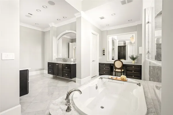 a spacious bathroom with a granite countertop double vanity sink and a bathtub