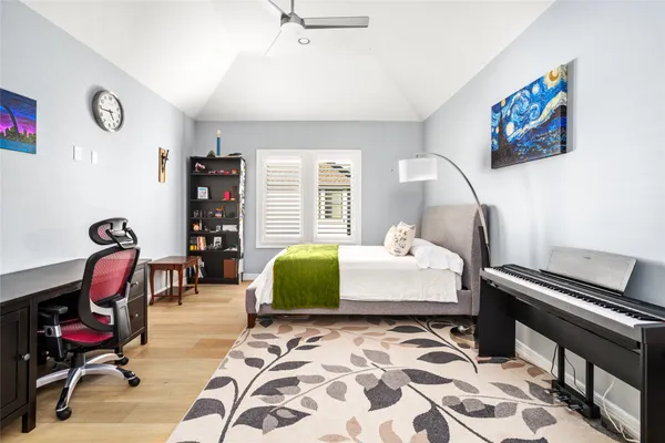 a bedroom with a bed chandelier and a window