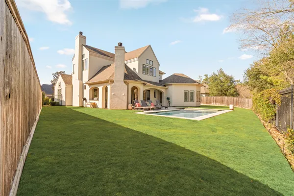 a view of a house with a big yard and large trees