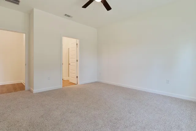 an empty room with closet and windows